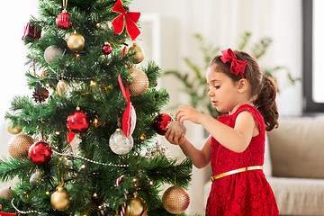 Image showing little girl decorating christmas tree at home