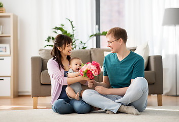 Image showing happy family with flowers and baby boy at home