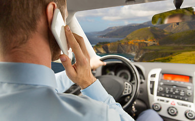 Image showing businessman calling on smartphone and driving car