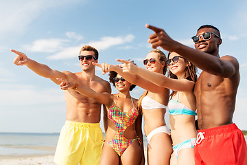 Image showing happy friends hugging on summer beach