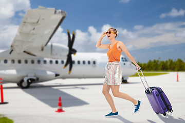 Image showing happy teenage girl with travel bag over plane