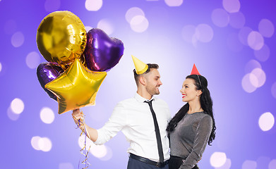 Image showing happy couple with party caps and balloons