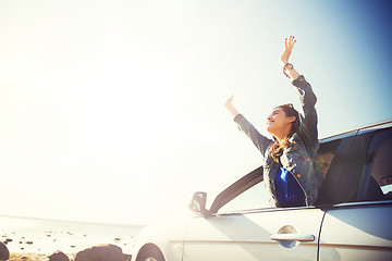 Image showing happy teenage girl or young woman in car