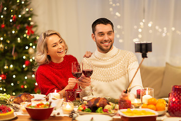 Image showing happy couple taking selfie at christmas dinner