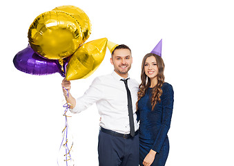 Image showing happy couple with party caps and balloons