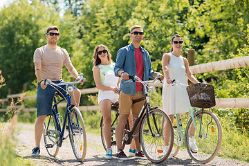 Image showing happy friends riding fixed gear bicycles in summer