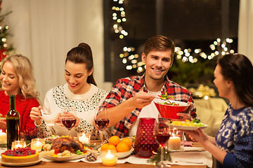 Image showing happy friends having christmas dinner at home