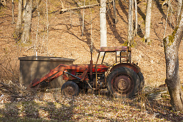 Image showing Red old tractor abandoned in a forest