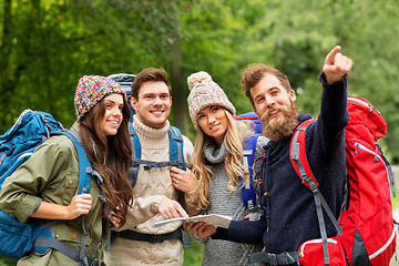 Image showing friends or travelers hiking with backpacks and map