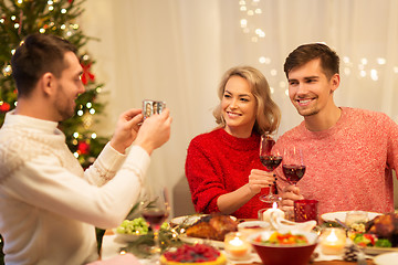 Image showing happy friends photographing at christmas dinner