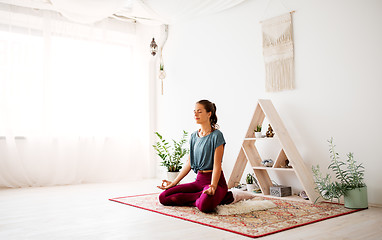 Image showing woman meditating in lotus pose at yoga studio