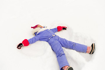 Image showing happy little girl making snow angels in winter
