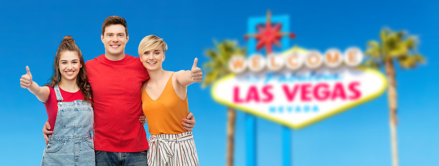 Image showing happy friends showing thumbs up at las vegas sign