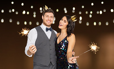 Image showing happy couple with crowns and sparklers at party