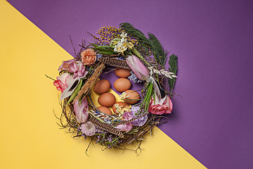 Image showing Easter card. Painted Easter eggs in nest on yellow background