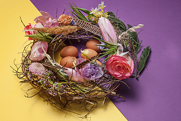 Image showing Easter card. Painted Easter eggs in nest on yellow background