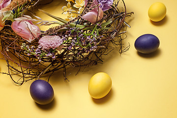 Image showing Easter card. Painted Easter eggs in nest on yellow background