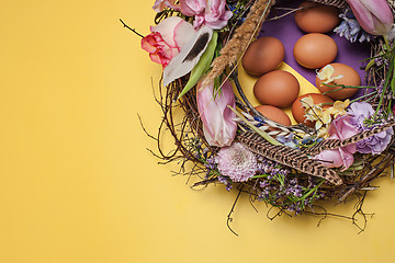 Image showing Easter card. Painted Easter eggs in nest on yellow background