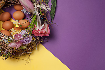 Image showing Easter card. Painted Easter eggs in nest on yellow background