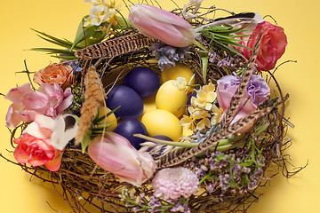 Image showing Easter card. Painted Easter eggs in nest on yellow background