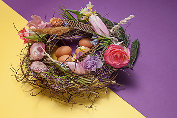 Image showing Easter card. Painted Easter eggs in nest on yellow background