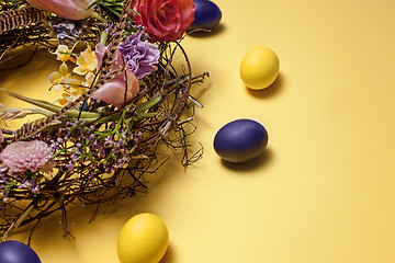 Image showing Easter card. Painted Easter eggs in nest on yellow background