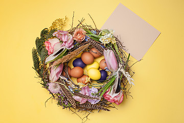 Image showing Easter card. Painted Easter eggs in nest on yellow background