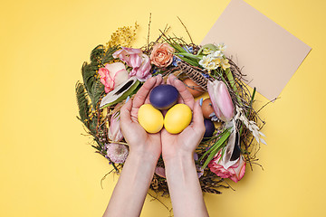 Image showing Easter card. Painted Easter eggs in nest on yellow background