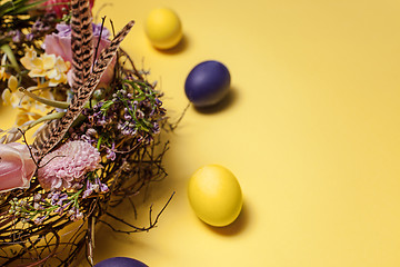 Image showing Easter card. Painted Easter eggs in nest on yellow background