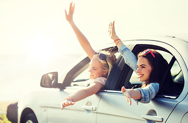 Image showing happy teenage girls or women in car at seaside