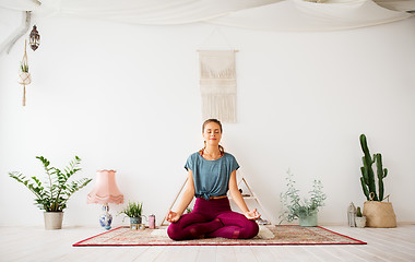 Image showing woman meditating in lotus pose at yoga studio