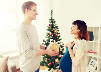 Image showing husband giving christmas present to pregnant wife