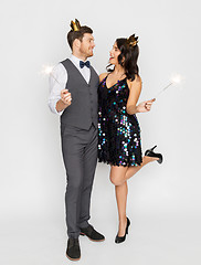 Image showing happy couple with crowns and sparklers at party