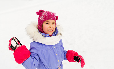 Image showing happy girl playing and throwing snowball in winter