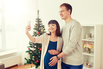 Image showing happy family couple taking selfie at christmas