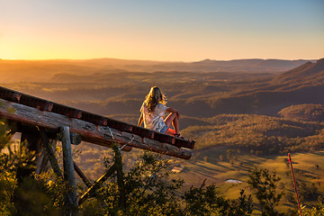 Image showing Female relaxing at Mt Blackheath watching the golden sunlight from wooden platform