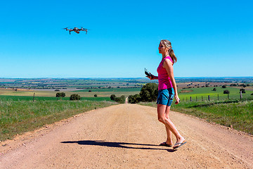 Image showing Woman flying a drone in rural landscape