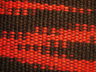 Image showing Close-up photo of red and black hand loomed fabric