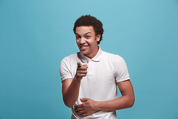 Image showing The happy business man point you and want you, half length closeup portrait on blue background.