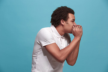 Image showing Isolated on blue young casual man shouting at studio