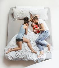 Image showing Top view of happy family with one newborn child in bedroom.