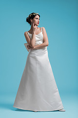 Image showing beautiful woman wearing wedding dress against cyan background