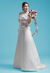 Image showing beautiful woman wearing wedding dress against cyan background