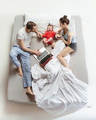 Image showing Top view of happy family with one newborn child in bedroom.