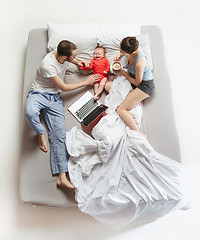 Image showing Top view of happy family with one newborn child in bedroom.