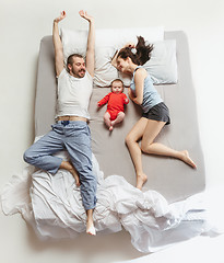 Image showing Top view of happy family with one newborn child in bedroom.