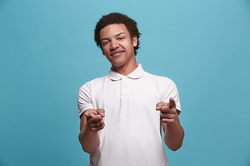 Image showing The happy business man point you and want you, half length closeup portrait on blue background.