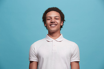 Image showing The happy business man standing and smiling against blue background.