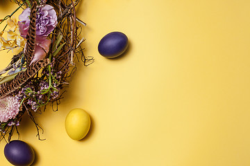 Image showing Easter card. Painted Easter eggs in nest on yellow background