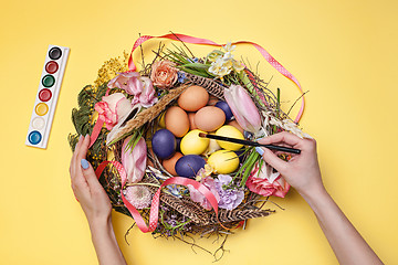 Image showing Easter card. Painted Easter eggs in nest on yellow background